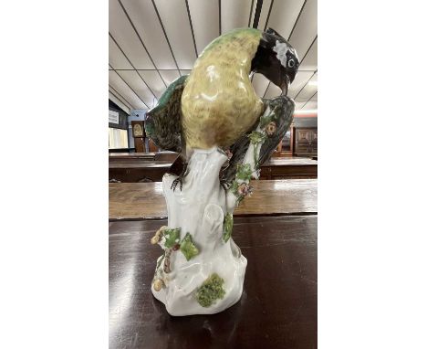 A Meissen style model of a bird on floral encrusted tree stump, 24cm high