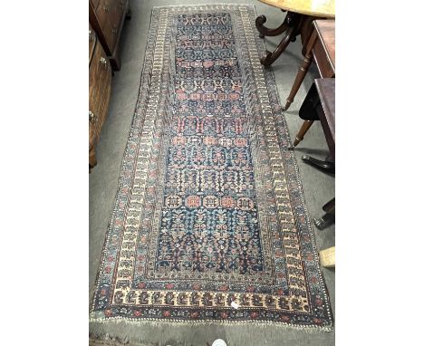 A 19th Century Persian carpet, the central blue panel with intricate geometric motifs surrounded by a four layer border, gene