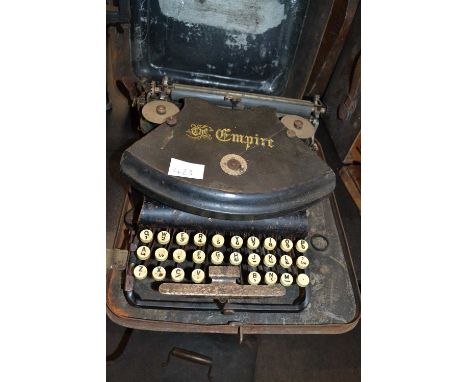 A vintage portable typewriter The Empire in metal travel case