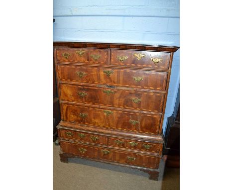 An early 18th Century walnut veneered and cross banded chest formed of two sections, the top section with two short over thre