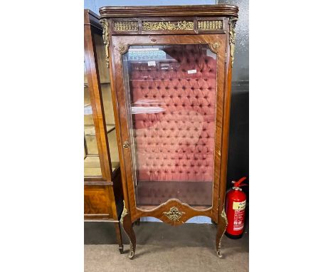 A reproduction French Vitrine display cabinet, the body with applied metal decoration raised on short swept legs, the interio