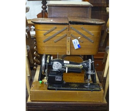 A Vintage Standard sewing machine, a teak cantilever sewing cabinet, and another 