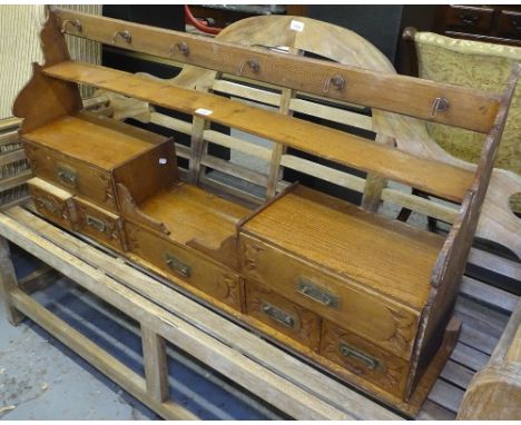 A Continental pine hanging shelf rack, with 7 short drawers, L123cm 