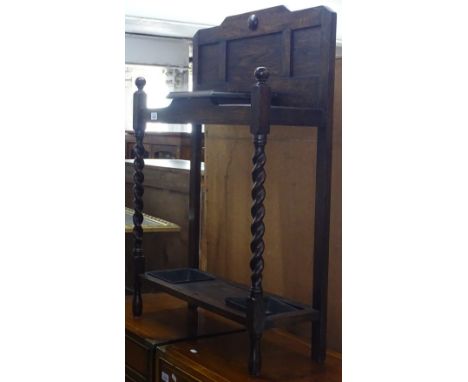 A 1920s oak stick stand with barley twist supports, W68cm 