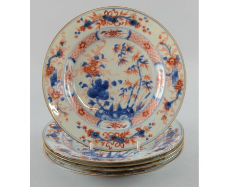 Five Chinese porcelain plates decorated in the Imari palette with flowering shrubs and bamboo, the borders with auspicious ob