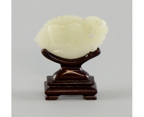 Chinese white jade carved as a cat asleep on a leaf, the reverse carved with a bat and Shou symbol, on carved wood stand, 7cm