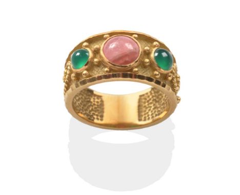 A Rhodochrosite and Emerald Ring, a round cabochon rhodochrosite between two round cabochon emeralds in rubbed over settings,