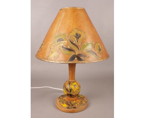 A 1940s wooden based table lamp with painted floral design and gilt borders.  New wiring.