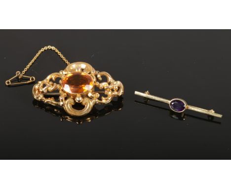 Two brooches, comprising of a 9ct gold bar brooch with a central Amethyst stone (4.5cm), together with a yellow metal brooch 