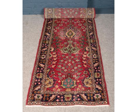 A vintage red ground fine woven Persian Kashan runner. Floral design. (303cm x 85cm).  