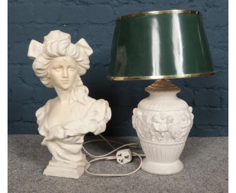 A bust and table lamp, comprising of a composite bust of a maiden, together with a plaster base lamp with cherub decoration a