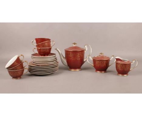 A Japanese 'Sone China' tea set with 12K gold gilt decoration and rust coloured background. Comprising of teapot, six cups, s