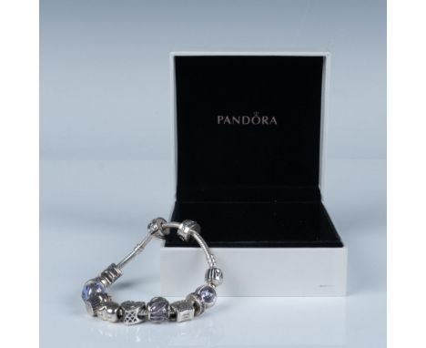 A signature sterling silver snake chain bracelet, complemented by thirteen sterling silver charms in various designs and them