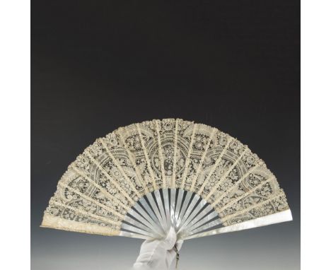 An elegant tasseled fan featuring a mother of pearl handle that beautifully shines alongside lace that is intricately designe