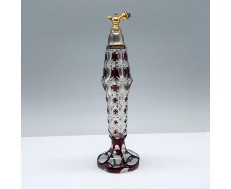 Faceted glass bottle adorned with intricate starburst designs and rich ruby overlay. Topped with an ornate brass finial, this