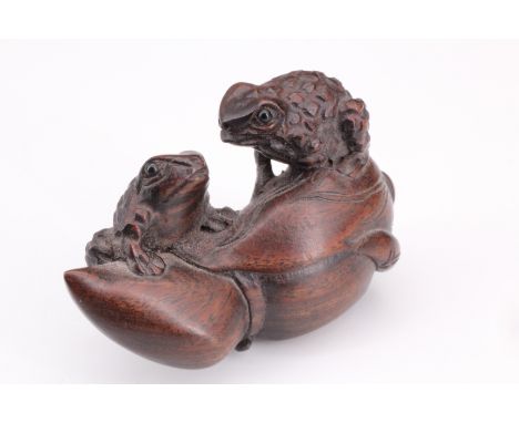 A Japanese carved wood netsuke of two frogs on a blossom, 4.5 cm