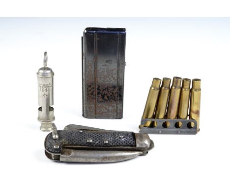 A clip of .303 cartridge cases together with a magazine, a clasp knife and a 1945 British army whistle
