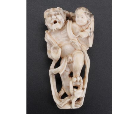 A Japanese ivory netsuke of an Oni carrying a child, 7 cm