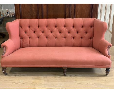 A late Victorian button-upholstered wing back low sofa, 195 cm wide x 85 cm high, seat 65 cm deep a 35 cm high