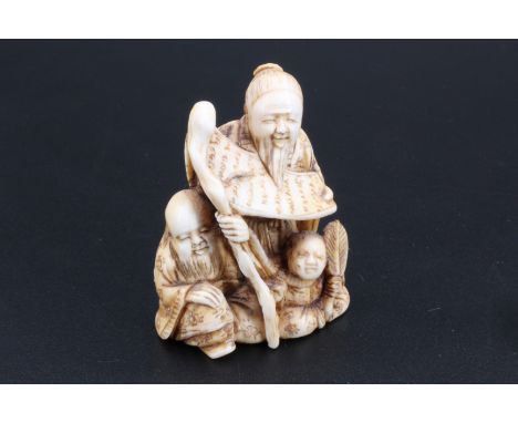 A Japanese ivory netsuke of two dignitaries with a child, 4.5 cm