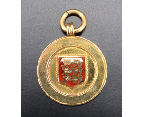 An enamelled 9 ct gold medal, bearing a shield enamelled with three golden lions in a red field with a truncated three point 