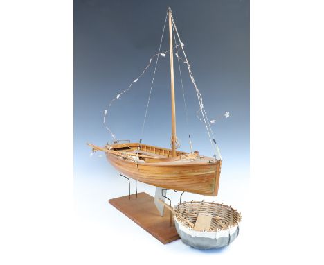 A wooden model yacht together with a coracle, first 62 cm