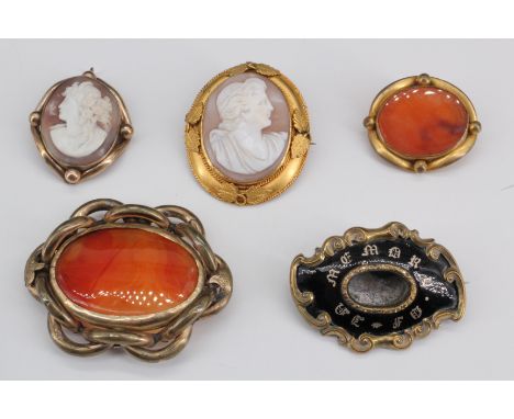 Four Victorian cameo and agate brooches, together with a Victorian gilt metal and black enamel mourning brooch, (crystal lock
