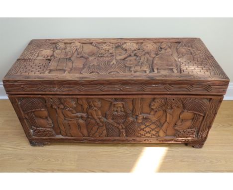 [Tribal art] A carved African hardwood chest, having a top and front carved with kings flanked by attendants, the sides and b