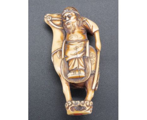 A Japanese ivory netsuke of a man on a camel, 5.5 cm