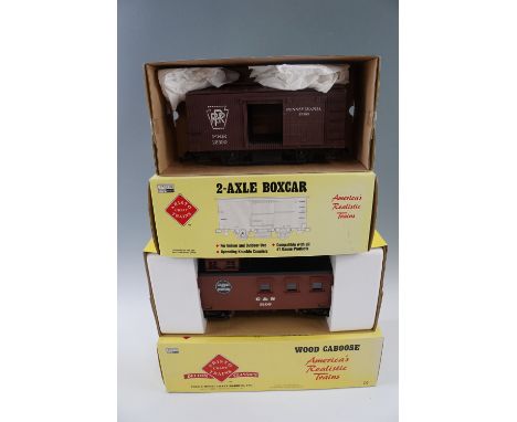 Two Aristocraft garden model railway rolling stock 2-axle box cars, together with a wood caboose