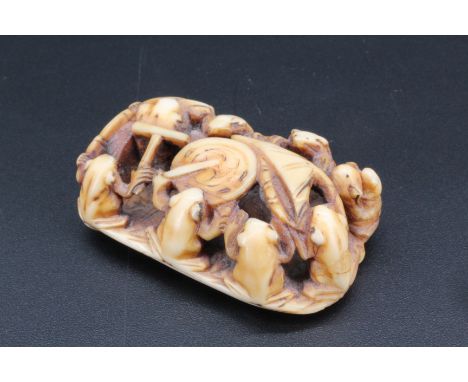 A Japanese ivory netsuke of frogs on a lily pad playing a drum, 4.5 cm