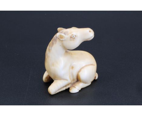 A Japanese ivory netsuke of a recumbent horse, 3.5 cm