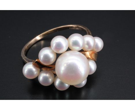 A Mikado pearl ring, comprising a central pearl of 8 mm set within a navette frame of ten further smaller pearls divided by a
