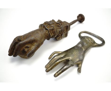 An Indian cast iron door knocker in the form of a hand grasping a fruit, together with a similar bottle opener 