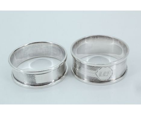 Two Silver napkin rings, the first being engine turned with a square raised edge and vacant escutcheon, Birmingham, 1958, the