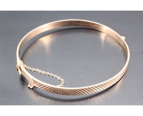A 9 ct gold bangle, decorated with cross hatch engraving, London, 2963, 5 mm x approximately 60 mm diameter, 9.34 g