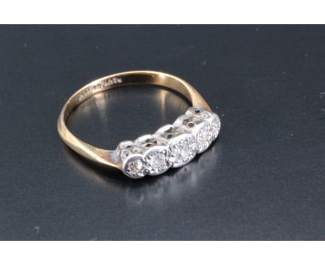 A five stone diamond ring, having five graduated illusion set round diamonds set in a platinum gallery on a tapering 18 carat