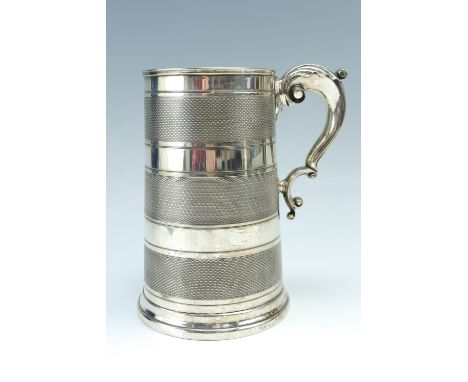 A late 19th / early 20th Century glass bottomed electroplate quart tankard decorated with banded engine turning, 21 cm