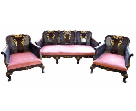 Walnut and mahogany Bergere three piece suite, comprising two armchairs and three seater sofa, each with central splat decora