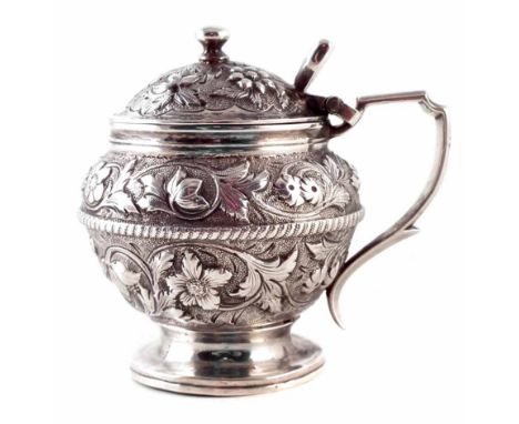 Georgian circular silver mustard pot, embossed with leaf and floral decoration, hinged domed lid with button finial, raised o