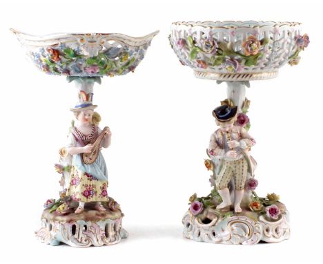 Two Carl Thieme Potschappel table centres, with pierced and encrusted basket bowls supported on tree stump bases with girl pl