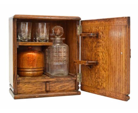 A small 20th century oak art deco drinks cabinet. Containing a pressed glass decanter and four glasses. With oak/ceramic pot 