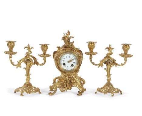 An early 20th Century French gilt brass clock garniture, the clock with white enamel dial with Roman and Arabic numerals set 