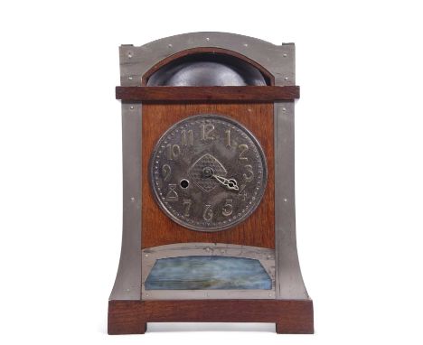 An unusual late 19th or early 20th Century mantel clock in the Arts &amp; Crafts style, the metal dial with raised Arabic num