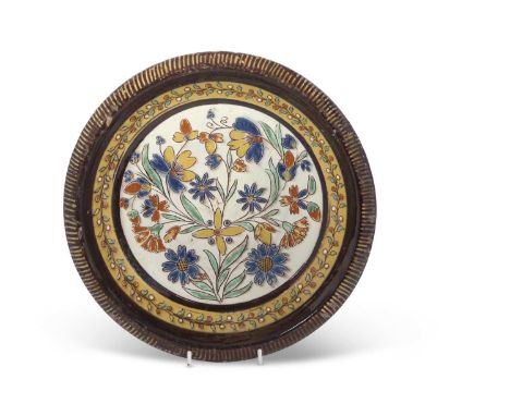 An unusual pottery dish with Iznik design to the centre within brown glazed Maiolica border, probably French, 29cm diameter