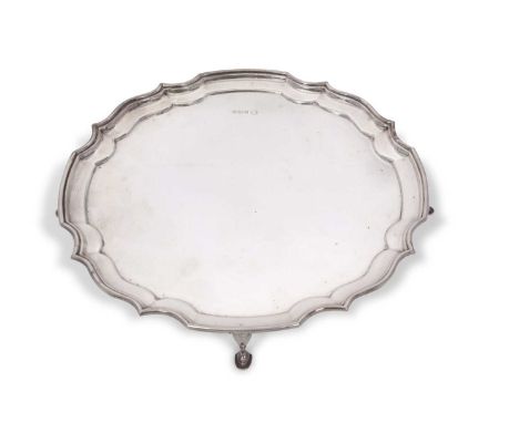 Elizabeth II silver salver of circular plain shaped form having raised Chippendale style border, supported on four hoof feet,