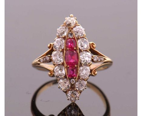 A ruby and diamond ring, the marquise shape plaque set to centre with three oval rubies (possibly synthetic), surrounded by o
