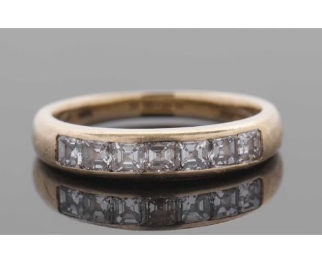 An 18ct diamond ring, the upper half, 4.3mm deep, set with channel set square emerald cut diamonds, total estimated approx. 1
