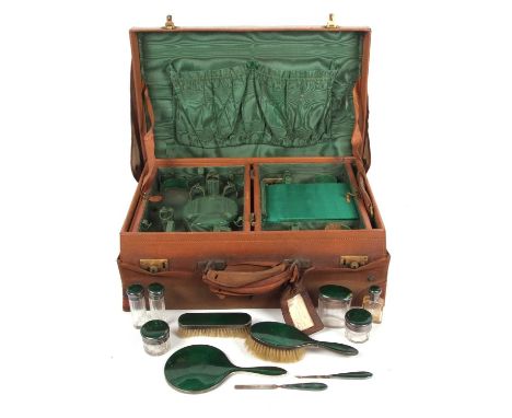 A George V silver and enamel travelling dressing table set in a leather case, Having two lift-out leather and silk lined tray