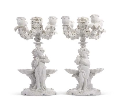 A pair of Meissen centrepieces and with four sconce candelabra, the stem supported by two large cherubs with shell moulded ei